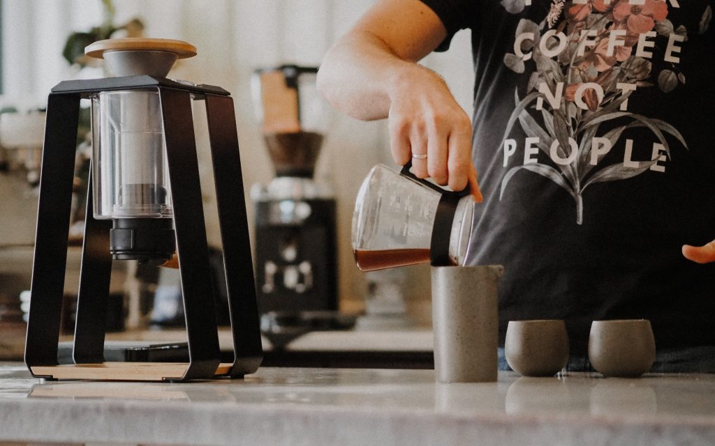 Un barista verse du café filtre de spécialité dans une carafe.