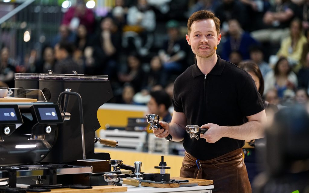 Le barista Anthony Douglas explique la technique de distribution Weiss lors du championnat mondial des barista à Melbourne en 2022.