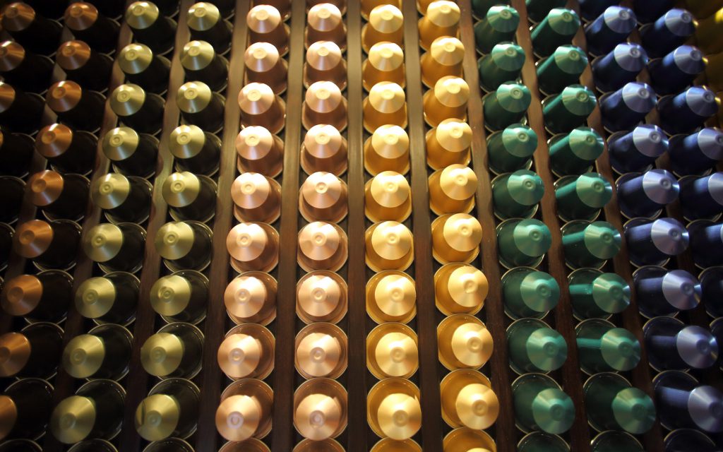 Rangées de différents types de capsules de café Nespresso.