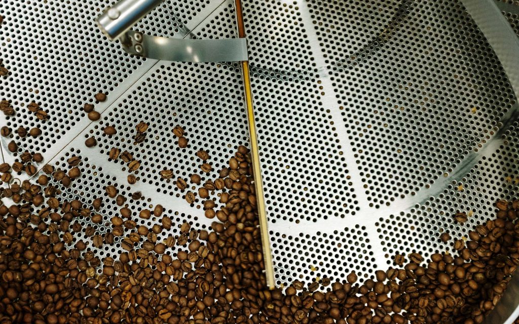 Grains de café torréfiés pour le lait dans un bac de refroidissement.