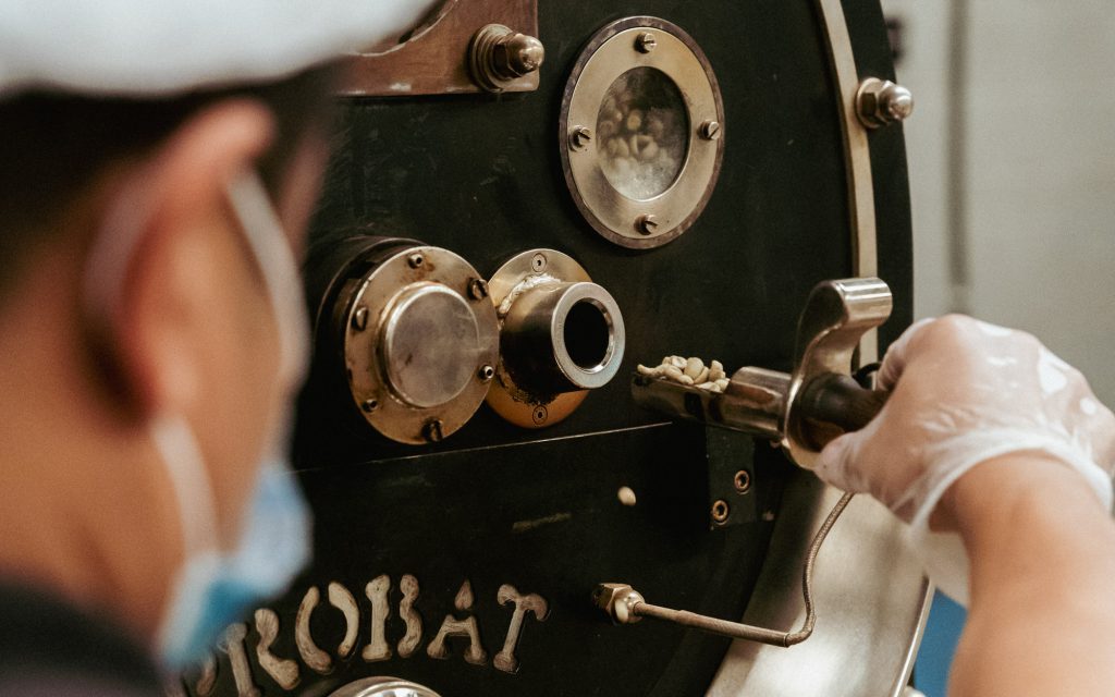 Un torréfacteur de Coffee Planet torréfie un mélange de café de spécialité sur une machine Probat.