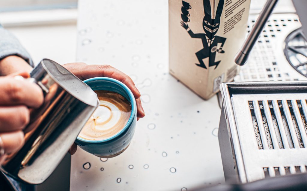 Un barista prépare un latte au lait d'avoine avec du lait d'avoine (non)ordinaire.